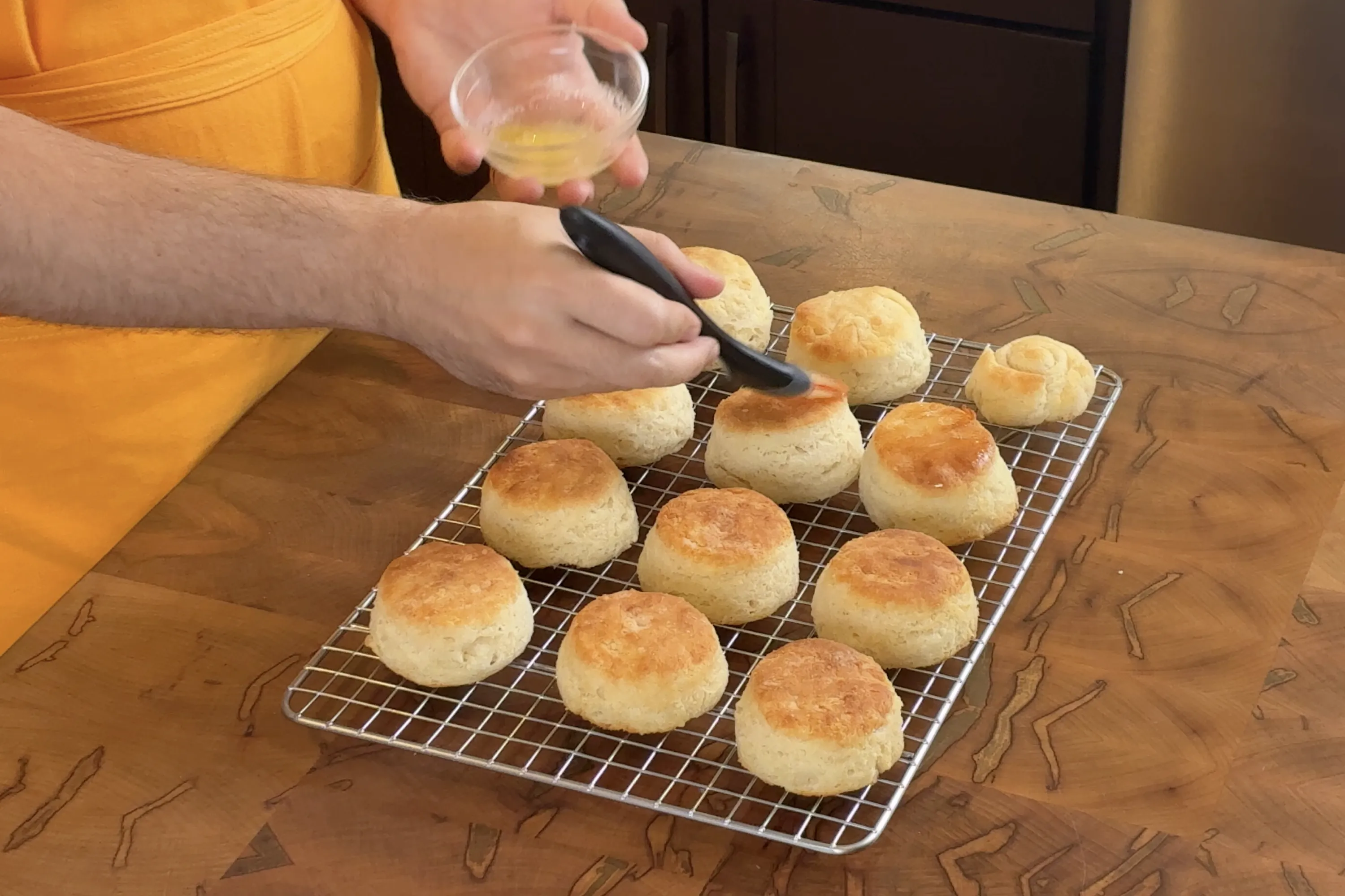 Brushing finished biscuits with butter