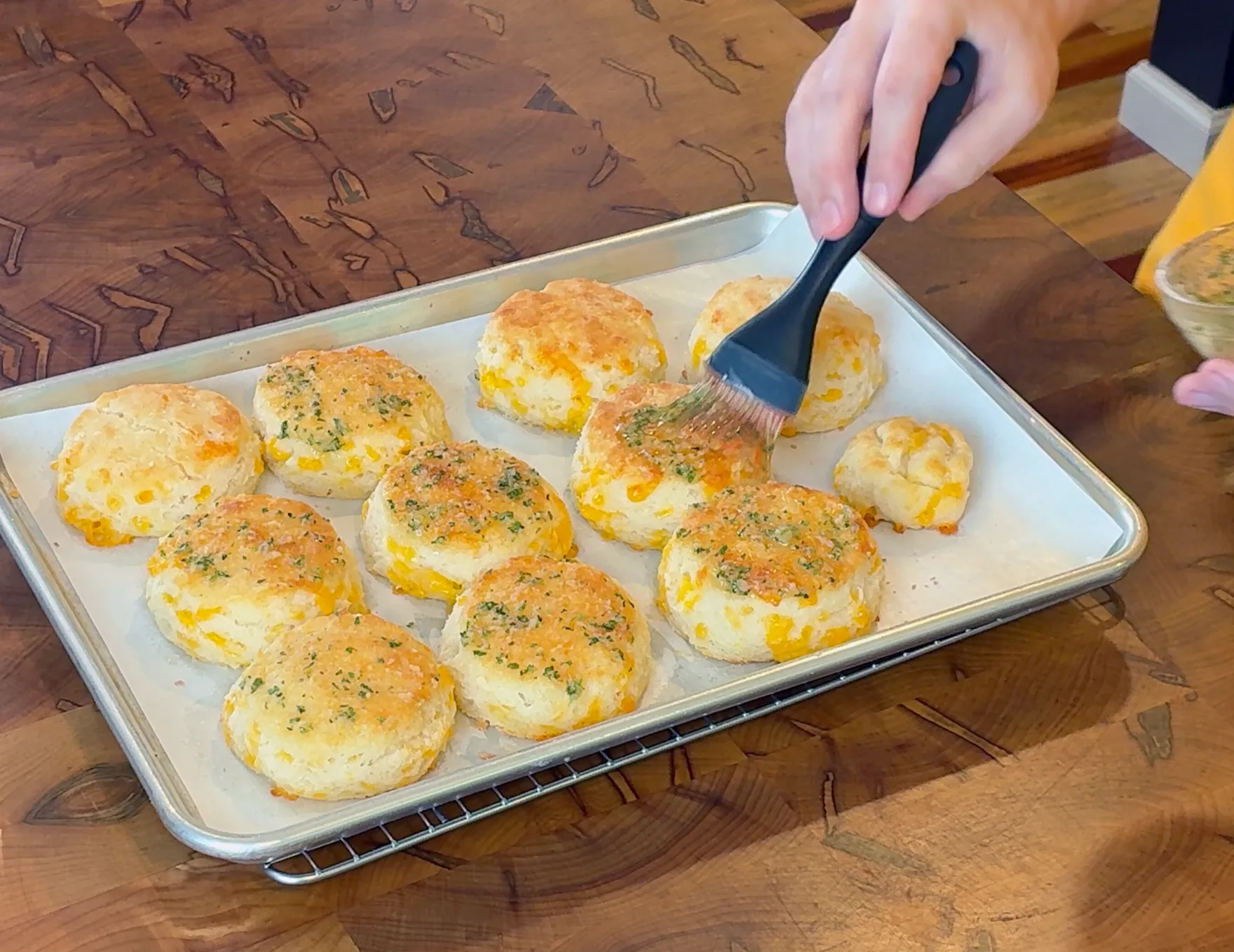 Brushing finished biscuits with butter